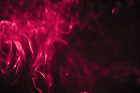 Red smoke in a dark room in a black backgroundの写真素材