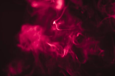 Red smoke in a dark room in a black background