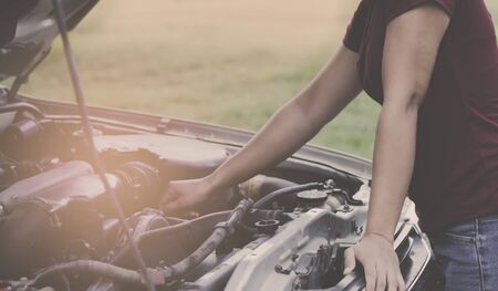 The girl who is checking the car engineの写真素材