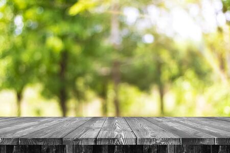 Wooden table with a green backdrop for your designの写真素材