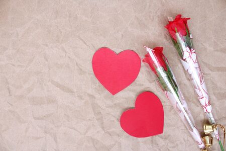 Red heart-shaped paper with fake roses on brown paper art on Valentines Dayの写真素材