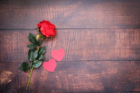 Paper hearts and red roses on dark wood floors and Valentines Day - Imageの写真素材