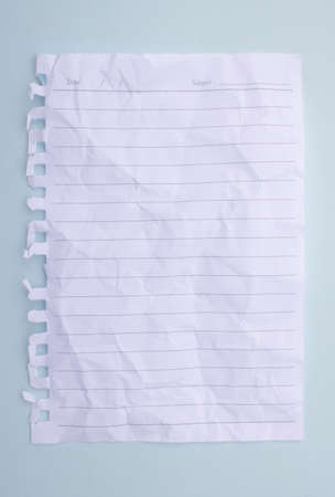 white paper with crumpled lines placed on a blue background. note paperの写真素材