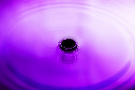 abstract purple splash water The surface of the water spreads in glittering circles. abstract backgroundの写真素材