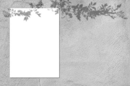 Blank white square poster mockup with light shadow on gray concrete wall background., top view.