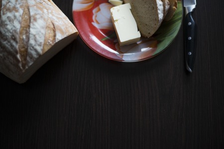bread, butter , a knife and a cup