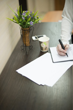 she writes pen on a pad on the table