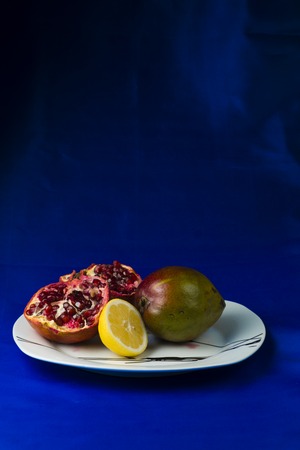 a pomegranate apple lemon on a plateの写真素材