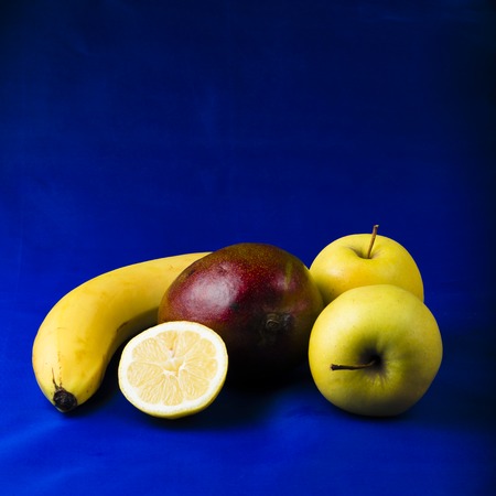 mango, lemon, apple on a blue backgroundの写真素材