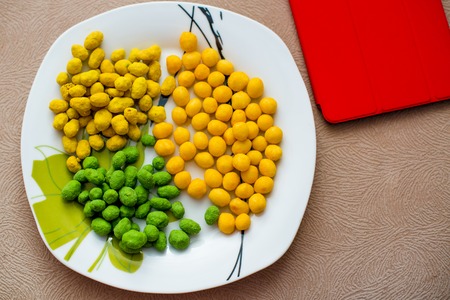 multicolored nuts on a white plate and tabletの写真素材