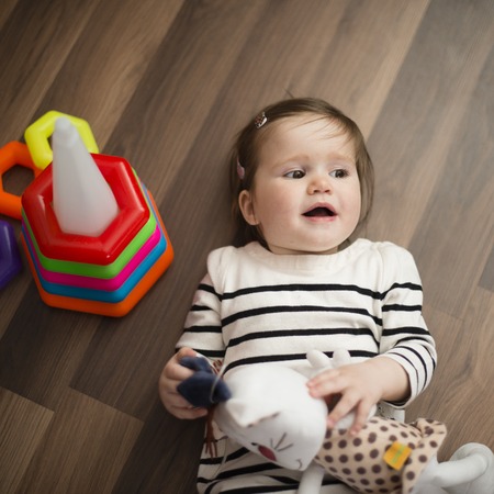 happy little girl lying on the floor and laughs