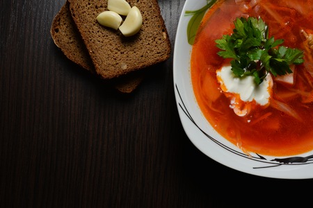 Red borsch with greens on a black tableの写真素材