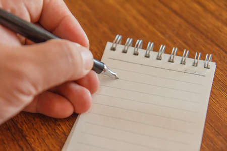 Blank notebook with pen and calculator on wooden table, business concept