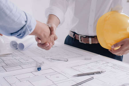 Architect and engineer construction workers shaking hands while working for teamwork. Engineer concept.の写真素材