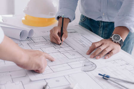 Two business man construction site engineer. Engineering tools on workplace Planning Design Draw Teamwork.の写真素材