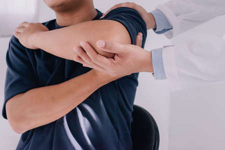 Professional therapists are stretching muscles, Physiotherapy, sport injury rehabilitation. Senior man exercises in center for chiropractic.の写真素材