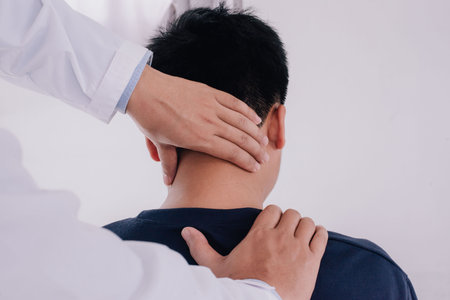 Doctor doing neck adjustment in medical office. Physical rehabilitation therapies and treatment of physiological disorders by physiotherapists concept.の写真素材