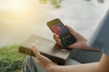 Woman worship with smartphone. Jesus on smartphone screen. Church online concept.の写真素材