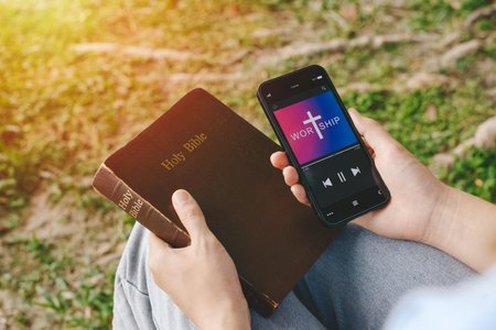Woman worship with smartphone. Jesus on smartphone screen. Church online concept.の写真素材