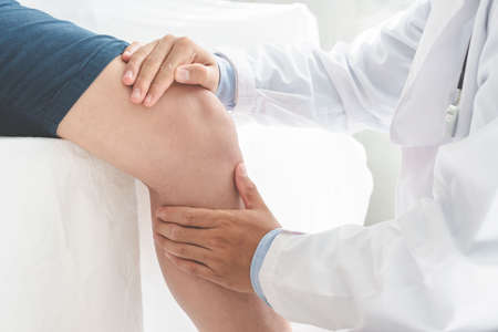 Physiotherapist doing healing treatment on patient leg. sport physical therapy concept, panoramic bannerの写真素材