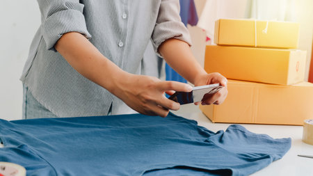 Asian women selling clothes online. Online Selling , Online Shopping and e-Commerce concept.