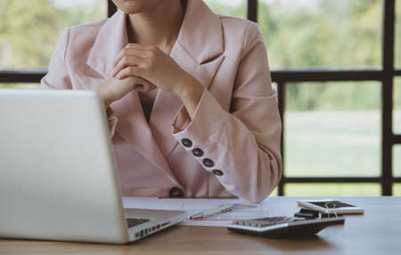 Young businesswoman working on laptop in her workstation. Close upの写真素材