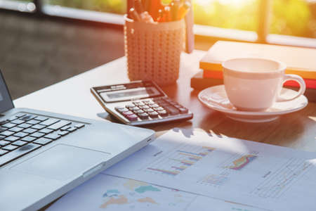 Sideview of office desktop with blank laptop and various office tools. Top view with copy space.の写真素材