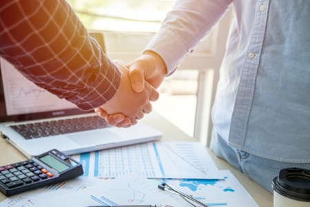 Two confident business man shaking hands during a meeting in the office, success.の写真素材