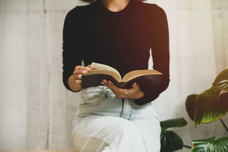 Women reading the old heavy book on white background.の写真素材