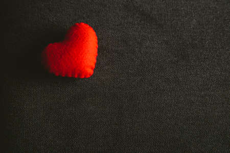 Giving red heart on wooden Background.の写真素材