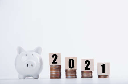 2021 New year saving money piggy bank with Wood word 2021. Money-saving conceptの写真素材