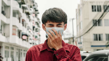 Man with medical face mask in the city. Air pollution, Concept of coronavirus quarantine. MERS-Cov, Novel coronavirus (2019-nCoV)の写真素材