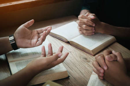 Christians are congregants join hands to pray and seek the blessings of God. Devotional or prayer meeting concept.の写真素材