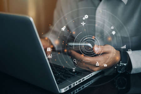 Businessman hand using mobile phone and laptop computer with digital layer effect. Big data...