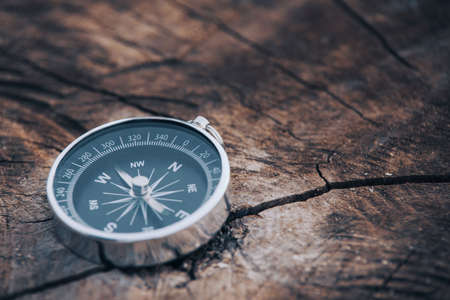 Magnetic compass on old brown wood. Vintage still life. Sailing accessories. Travel, navigation, collecting, souvenir, gift, graphic resources, copy spaceの写真素材
