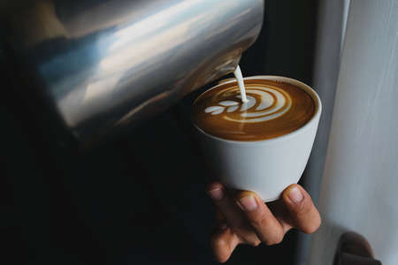 Barista focus in milk and coffee in coffee shop cafe in vintage color tone.の写真素材