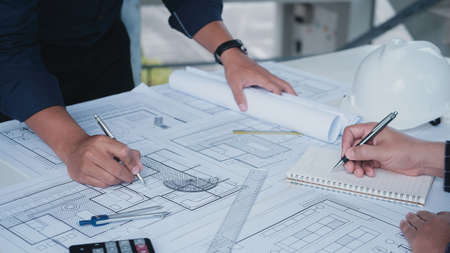 Builder two asian young engineer man construction site engineer. Engineering objects on workplace with partners interacting on background. Real-estate conceptの写真素材