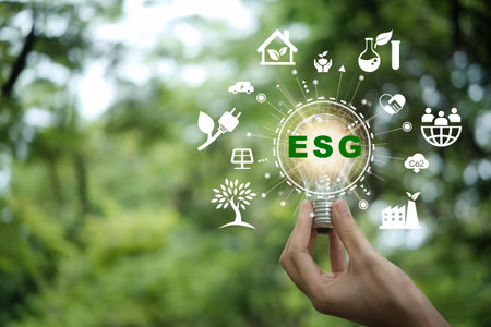 Hand holding light bulb with ESG icon concept for environmental, social, and governance in...