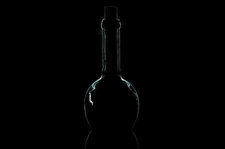 outline of a glass bottle on a black backgroundの写真素材