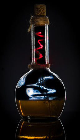 A bottle of whiskey with a lightning on a black backgroundの写真素材