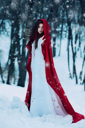 Red Riding Hood lost in the mystical snow-covered forest,fantastic shooting,fashionable toning, creative computer colorsの写真素材