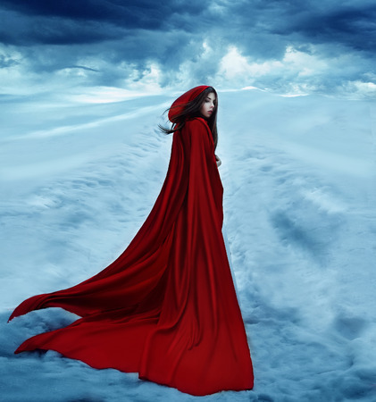 Little Red Riding Hood is going away on a snowy road and clouds. Dramatic and fantastic shooting,fashionable toning, creative computer colorsの写真素材