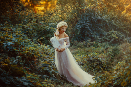 The beautiful countess in a long pastel dress  is walking in a green forest full of branches, elf,  Princess in vintage dress, the queen of the forest,fashionable toning creative computer colorsの写真素材