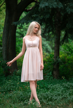 The girl in transparent dress with long flying pastel loop walks in spring wood , shabby chic , bohemian style , fashion creative computer colorの写真素材
