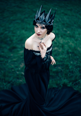 dark evil queen sneaks through the green field at cosplay moviesnow white, wild Princess , vampire , hip toning , creative color,dark bohoの写真素材