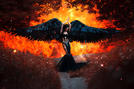 Black Angel. Pretty girl-demon with black wings. An image for Halloween. Image of an old book of fairy tales. Fashionable toningの写真素材