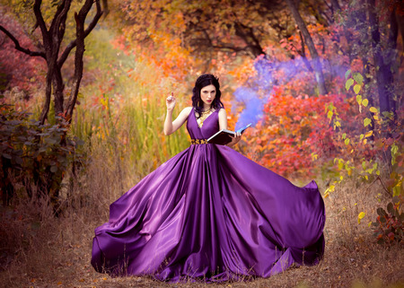Lady in a luxury lush purple dress ,fantastic shot,fairytale princess is walking in the autumn forest,fashionable toning,creative computer colorsの写真素材