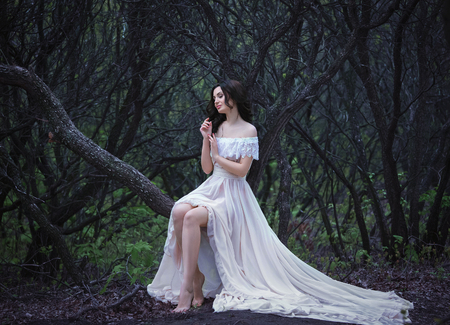beautiful spring walk in the woods among the  cherry blossom in Aprila lady in a long dress pastel , creative computer colors, fashionable toningの写真素材