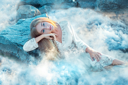 Fairy lies on a stone, shrouded in thick fog. Fashionable toningの写真素材