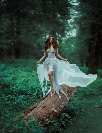 Fantastic photo shoot of a luxury elf.Great long dress handmade. Cute beautiful fairy with long hair. Natural landscapes the magical world of the forest.Toning fashion.Creative color.の写真素材